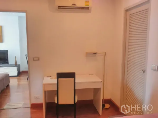 Condominium for rent in Watthana, Bangkok - Compact study nook with a white desk, chair and built-in storage next to the living area