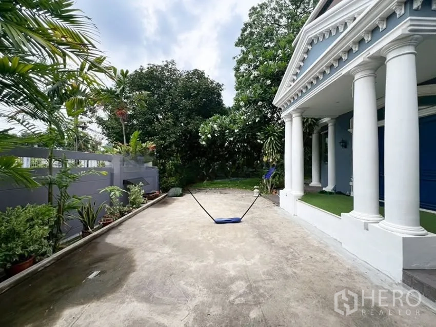 บ้านเดี่ยว for rent in Phra Khanong, Bangkok - ลานจอดรถกว้างหน้าบ้านพร้อมเฉลียงเสากลมและสวนร่มรื่น