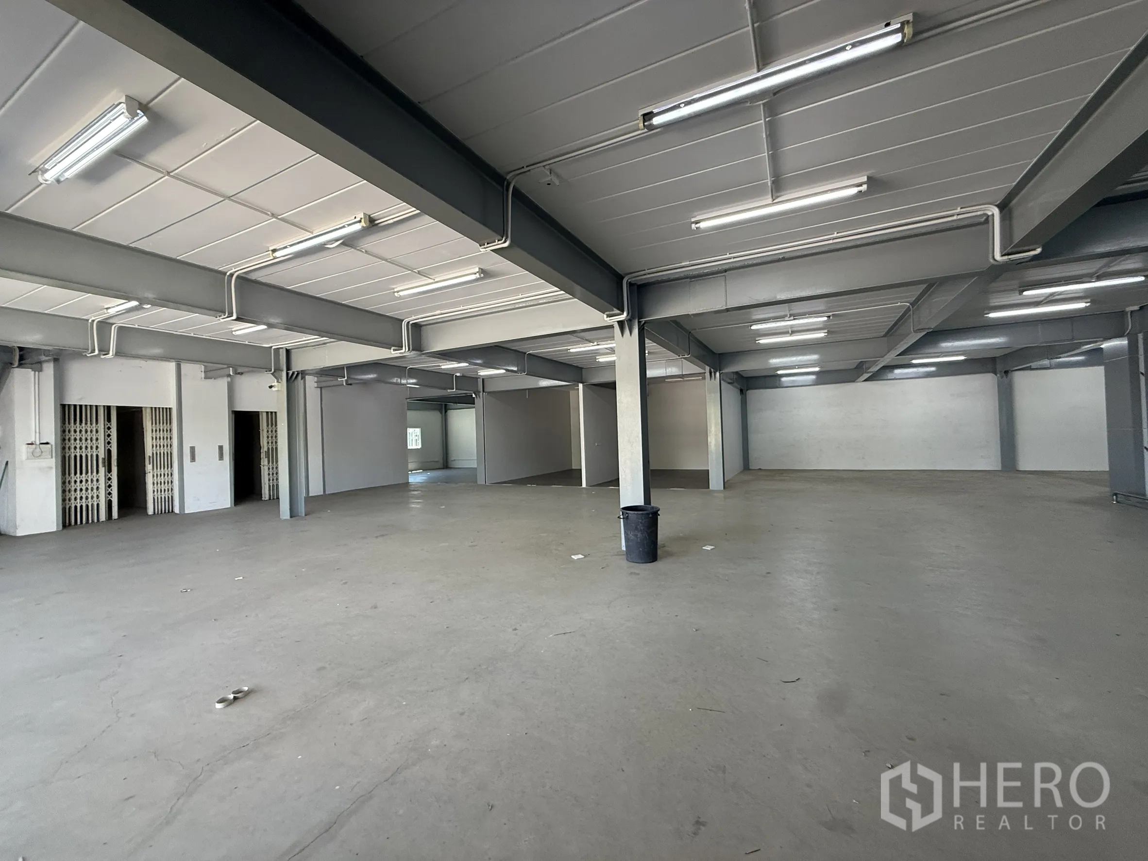 Warehouse for rent in Bueng Kum, Bangkok - Ground-level warehouse space with fluorescent lights and wide floor area.