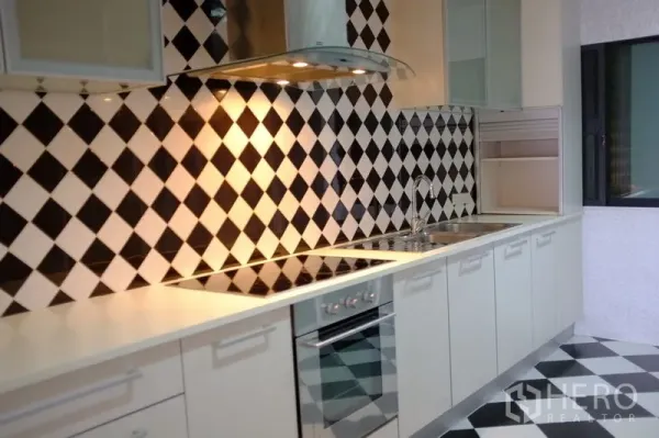 公寓 出租在Watthana, Bangkok - 现代白色厨房，黑白菱格墙砖，感应炉与不锈钢烟机。