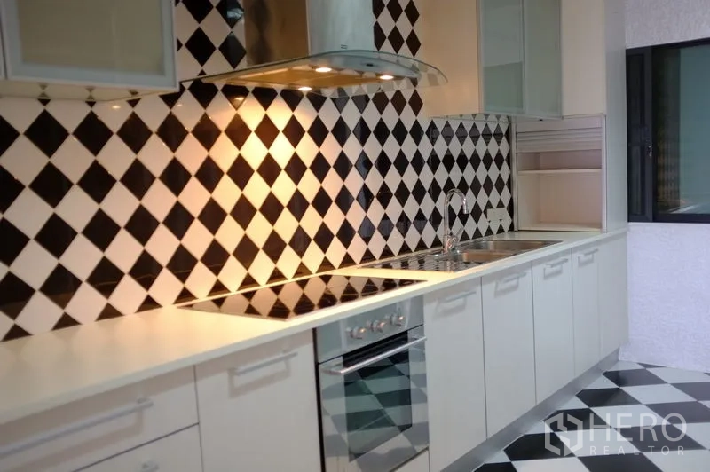 公寓 出租在Watthana, Bangkok - 现代白色厨房，黑白菱格墙砖，感应炉与不锈钢烟机。