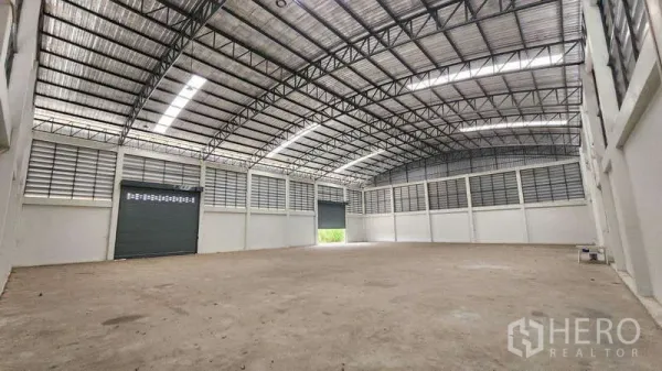 工厂 出租在Ban Phaeo, Samut Sakhon - 工厂内部空间宽敞，拱形钢结构屋顶，天窗采光、百叶通风与大型卷闸门。