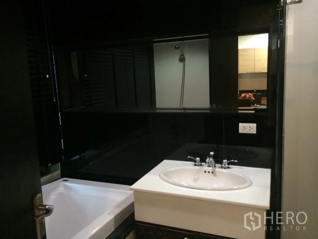 คอนโด ให้เช่าหรือขายในPathum Wan, Bangkok - ห้องน้ำสไตล์โมเดิร์นพร้อมอ่างอาบน้ำ อ่างล้างมือสีขาว และผนังกระเบื้องโทนเข้ม