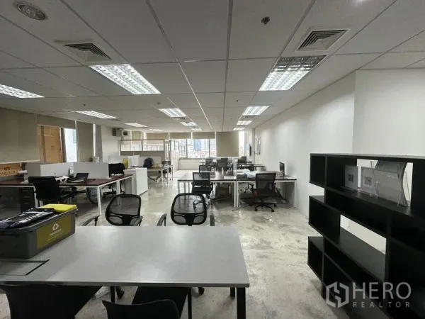 Office Space for rent in Khlong Toei, Bangkok - Spacious open office with multiple desks, shelving and suspended ceiling lights.