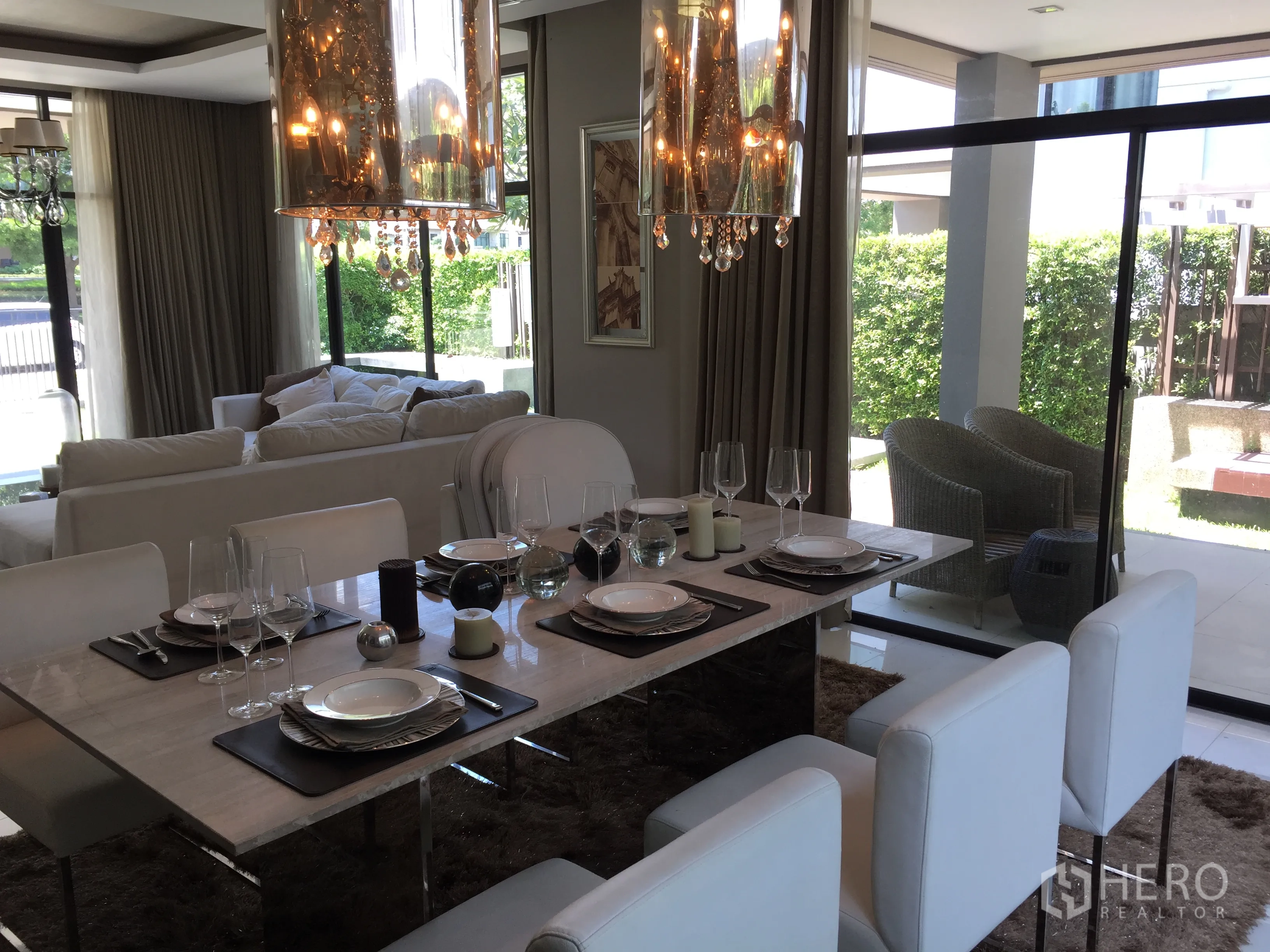 Detached House for sale in Prawet, Bangkok - Dining room with marble table, crystal pendant lights and garden-facing sliding doors.