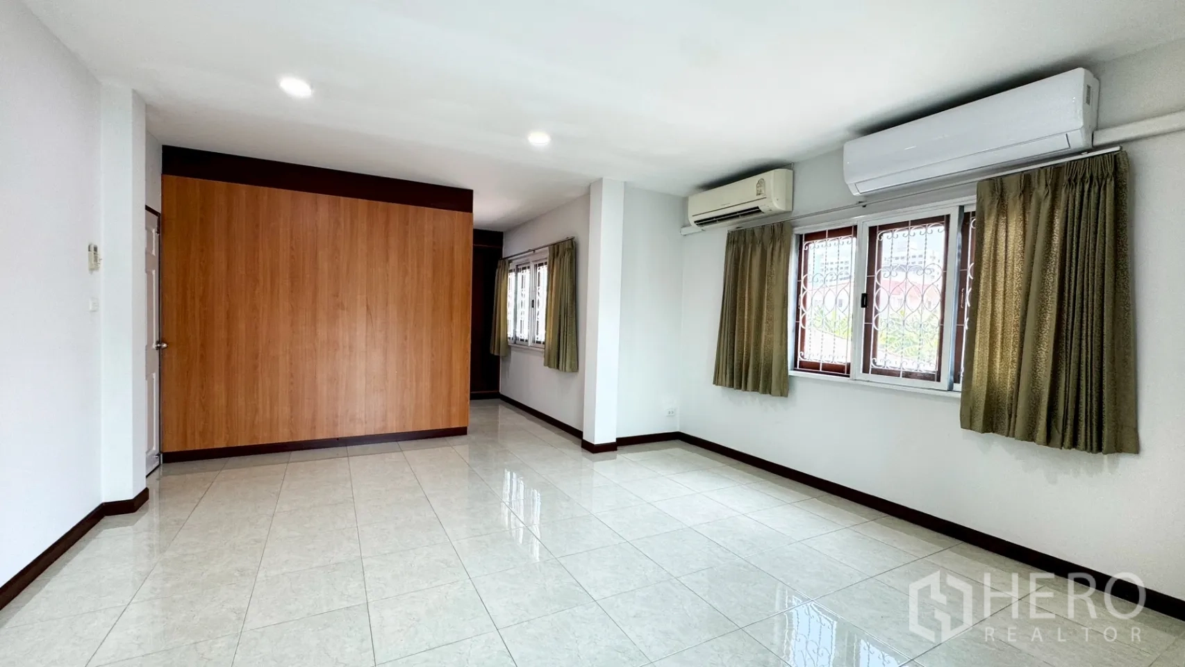 独栋房屋 for rent in Suan Luang, Bangkok - 大卧室配两台空调，多扇带护栏与窗帘的窗户。