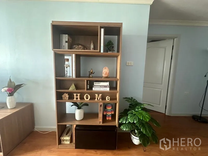 Condominium for rent in Watthana, Bangkok - Modern open shelving with decor accents and indoor plants in the living area.