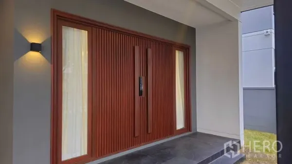 独立式住宅 出售在Sai Mai, Bangkok - 木质格栅入户门，配侧窗与门廊壁灯。