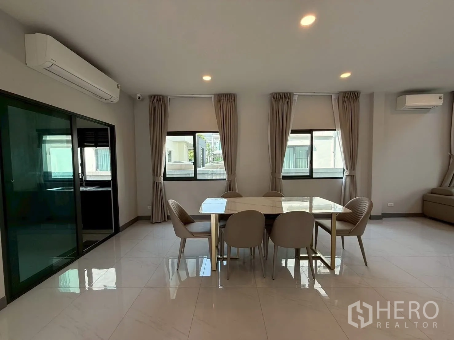 Townhouse for rent - Open‑plan dining space with sliding glass door to the kitchen and recessed ceiling lights.