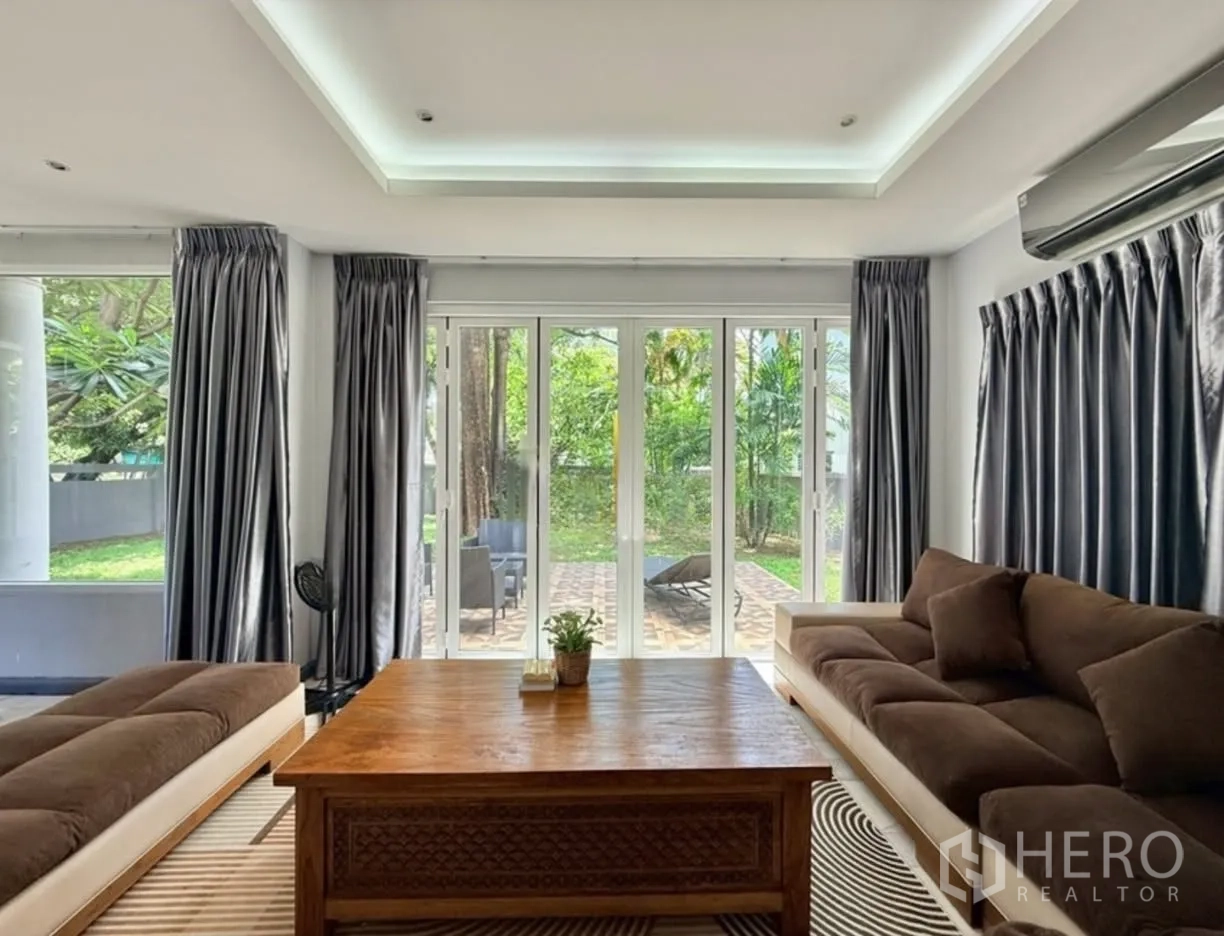 บ้านเดี่ยว for rent in Phra Khanong, Bangkok - ห้องนั่งเล่นประตูกระจกบานเลื่อนเปิดสู่เฉลียงและสวน
