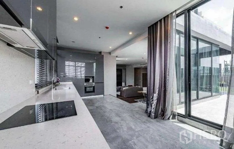 Condominium for rent - Kitchen with built-in appliances opening to a terrace through sliding glass doors.