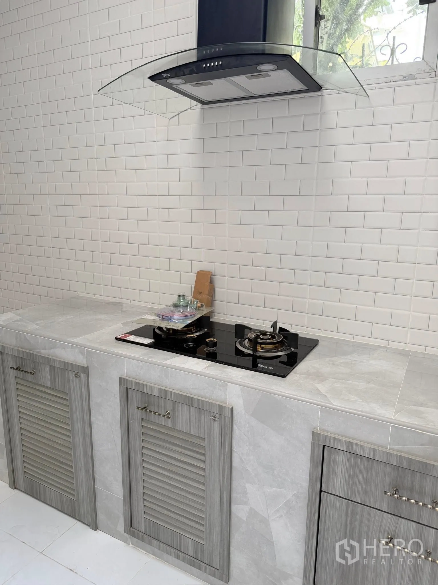 联排别墅 for rent or sale in Yan Nawa, Bangkok - 灶台与抽油烟机特写，旁有小窗