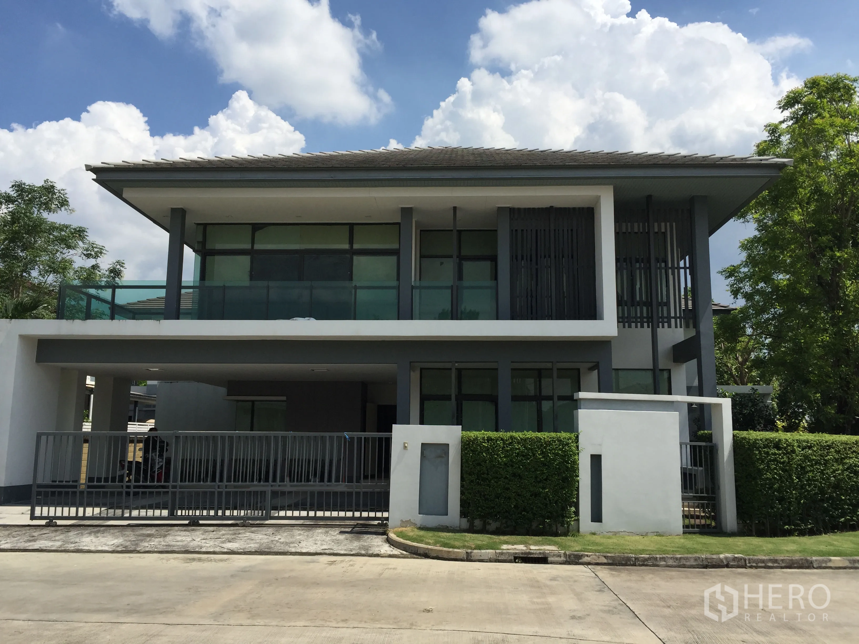 Detached House for rent or sale in Bang Kapi, Bangkok - Modern two-storey detached house with balcony, gated carport and neat hedges in a private estate.