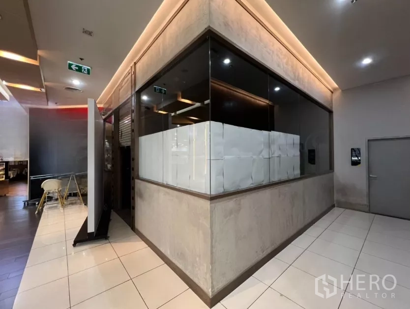 พื้นที่ขายปลีก ให้เช่า - ยูนิตค้าปลีกมุมกระจกในศูนย์การค้า พื้นกระเบื้องและไฟเพดานโทนอุ่น