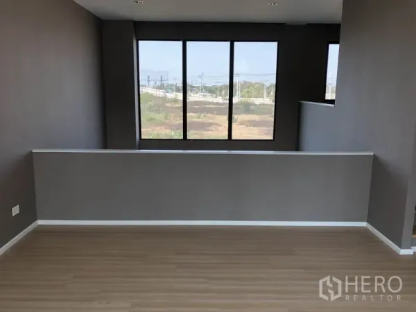 Townhouse for sale in Saphan Sung, Bangkok - Upper-floor multipurpose area with large windows and open neighborhood views.