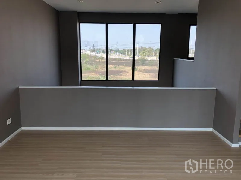 Townhouse for sale in Saphan Sung, Bangkok - Upper-floor multipurpose area with large windows and open neighborhood views.