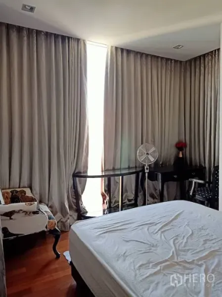 คอนโด ให้เช่าในKhlong Toei, Bangkok - ห้องนอนพร้อมผ้าม่านทึบ เตียงปูผ้าสีขาว โต๊ะทำงาน และพื้นไม้