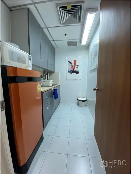 办公空间 出租在Khlong Toei, Bangkok - 办公室茶水间，橙色冰箱、微波炉、水槽与灰色吊柜，白色地砖。