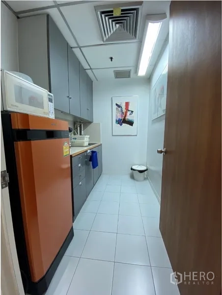 办公空间 出租在Khlong Toei, Bangkok - 办公室茶水间，橙色冰箱、微波炉、水槽与灰色吊柜，白色地砖。
