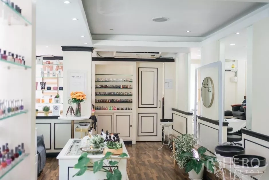 พื้นที่ขายปลีก ให้เช่า - ภายในสว่าง มีชั้นวางสินค้า ตู้บิวท์อินสีขาว และพื้นไม้