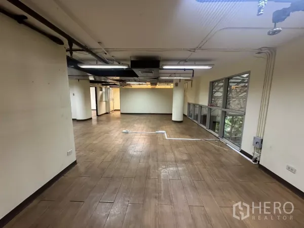 คลังสินค้า ให้เช่า - โซนใช้งานกว้างพร้อมหน้าต่างยาวด้านข้าง ท่อลมบนเพดาน และพื้นโทนไม้