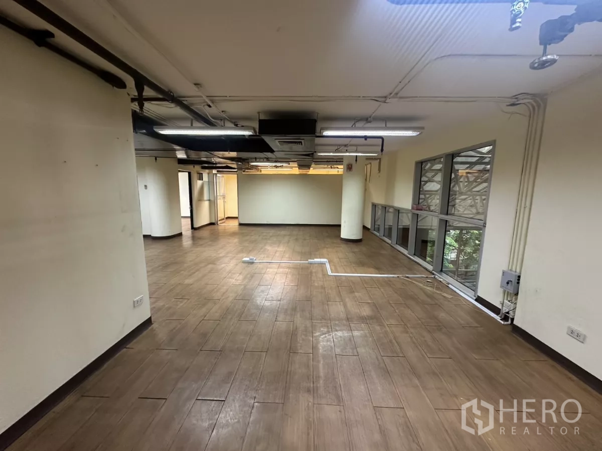 คลังสินค้า ให้เช่า - โซนใช้งานกว้างพร้อมหน้าต่างยาวด้านข้าง ท่อลมบนเพดาน และพื้นโทนไม้