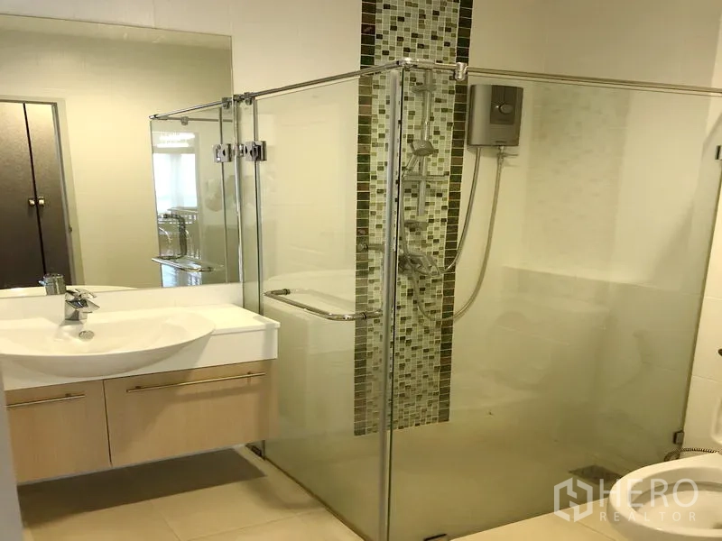 Detached House for rent or sale in Saphan Sung, Bangkok - Bathroom with glass shower enclosure, vanity and water heater.