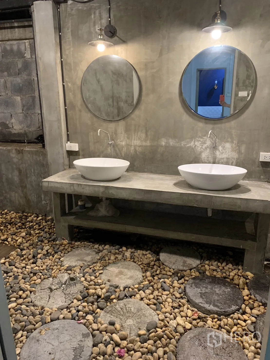 联排别墅 出租在Watthana, Bangkok - 混凝土工业风双台盆，圆形镜子与卵石地面。