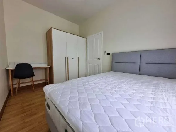 ทาวน์เฮาส์ ให้เช่าในWang Thonglang, Bangkok - ห้องนอนสว่างพร้อมเตียงหัวบุผ้า ตู้เสื้อผ้าสีขาว โต๊ะทำงาน และพื้นลามิเนตไม้