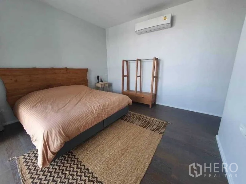 Detached House for rent or sale in Prawet, Bangkok - Minimal bedroom with bed, air-conditioning and woven rug.