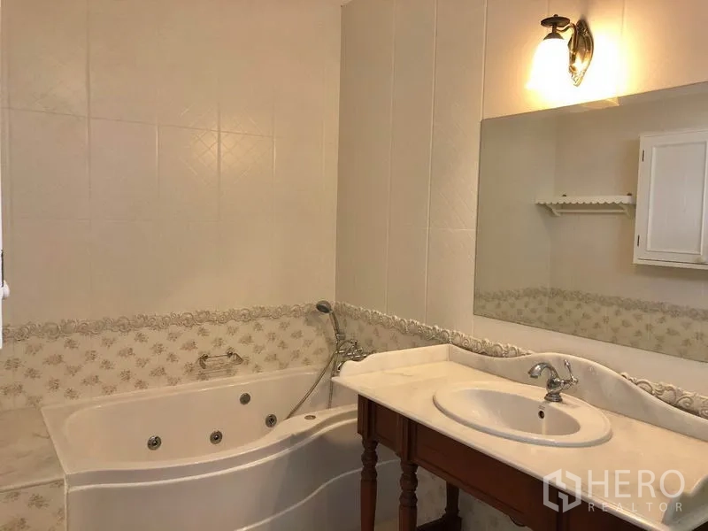 独立式住宅 出租在Mueang Samut Prakan, Samut Prakan - 浴室配按摩浴缸，大镜面与大理石洗手台，壁灯照明