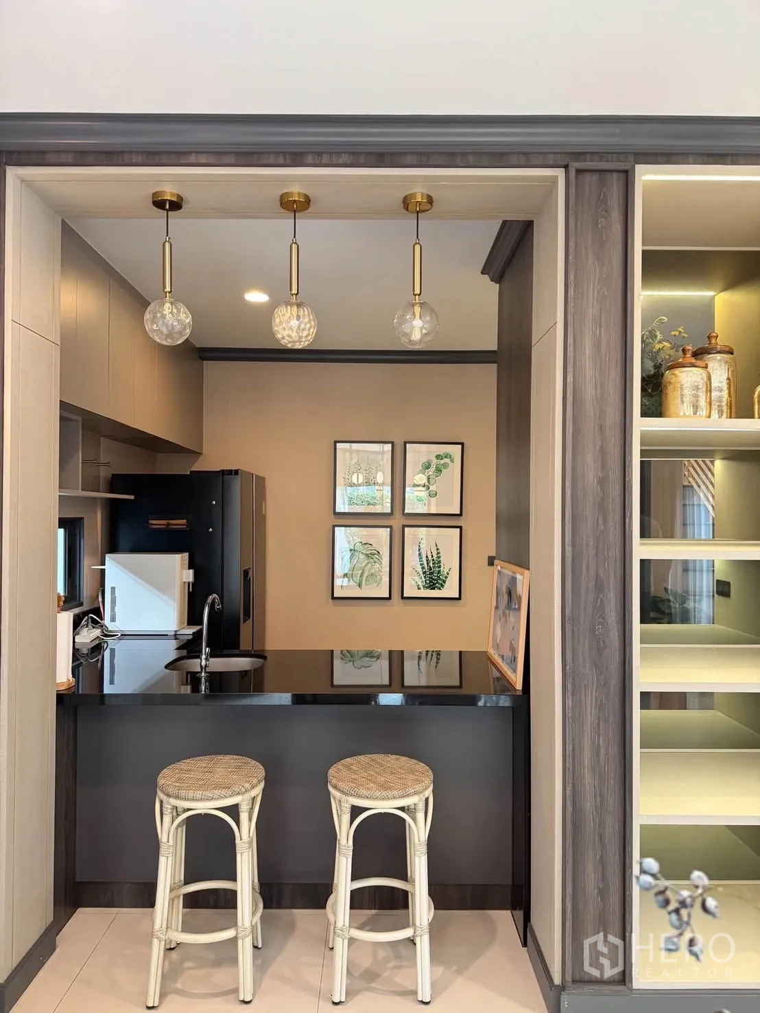 บ้านเดี่ยว for rent in Bang Kapi, Bangkok - ครัวบาร์ท็อปสีดำพร้อมอ่างล้างจาน โคมไฟห้อยสามดวง และสตูลสองตัว
