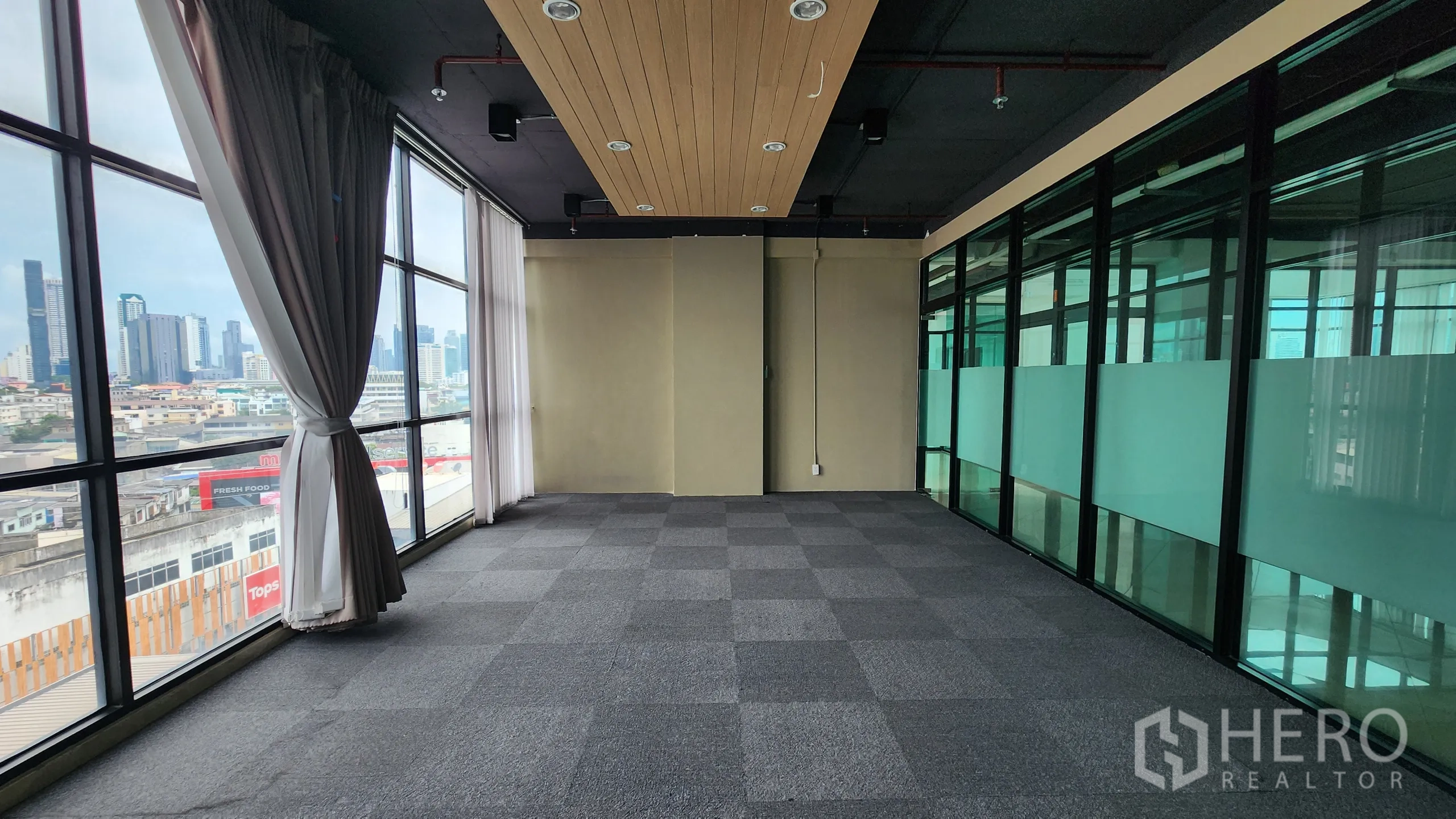 Office Space for rent in Yan Nawa, Bangkok - Carpeted office with wall-mounted air conditioner and wood accent panel.