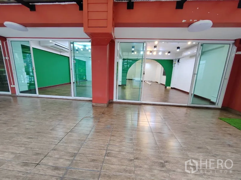 พื้นที่ขายปลีก ให้เช่าในKhlong Toei, Bangkok - ด้านหน้าร้านกระจกบานเลื่อน โครงสีแดง พื้นกระเบื้องลายไม้
