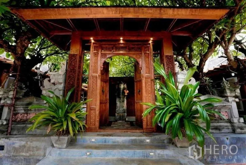 Detached House for sale in Bueng Kum, Bangkok - Ornate carved wooden entry gate framed by tropical plants.