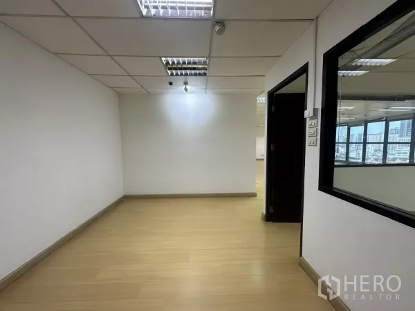 Office Space for rent in Watthana, Bangkok - Entrance or breakout area with wood flooring, white walls and an interior window to the main office.