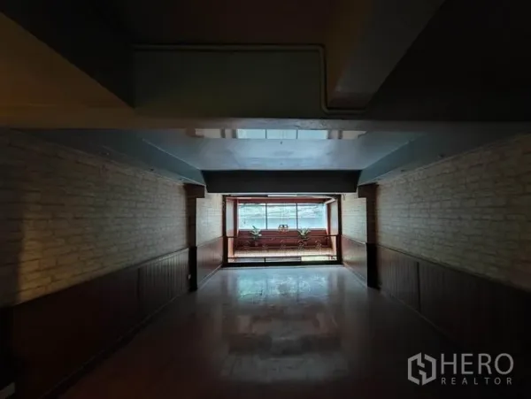 Shophouse for rent in Khlong Toei, Bangkok - Upper floor room with wide front window, wood details and a lightwell.