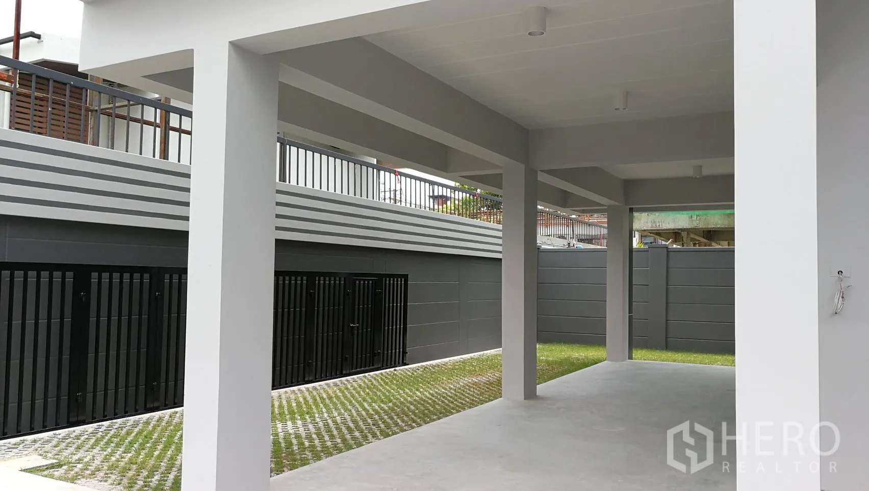 Townhouse for rent in Din Daeng, Bangkok - Covered carport with gated yard and small grass strip at the townhouse.