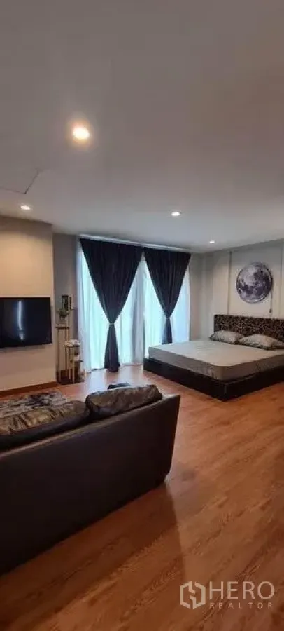 Townhouse for sale in Suan Luang, Bangkok - Spacious bedroom suite with bed, sofa, wood flooring and floor-to-ceiling curtains.
