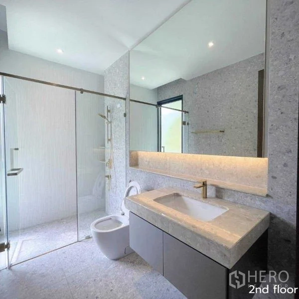 Detached House for rent in Bang Kapi, Bangkok - Contemporary bathroom with glass shower, wide mirror and soft lighting.