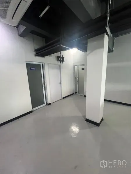 零售空间 出租在Watthana, Bangkok - 带多扇门的后勤区，可作储物或员工间，顶部外露风管。