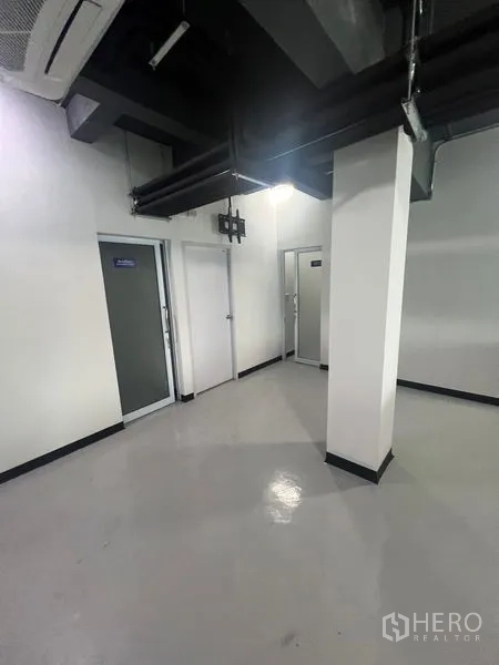 零售空间 出租在Watthana, Bangkok - 带多扇门的后勤区，可作储物或员工间，顶部外露风管。