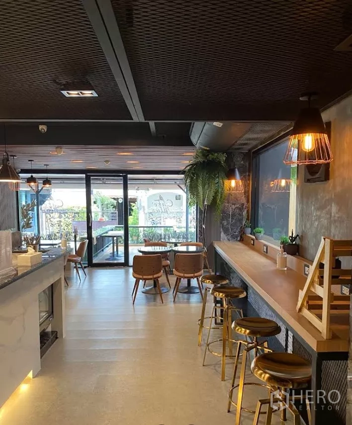 พื้นที่ขายปลีก ให้เช่าในKhlong Toei, Bangkok - พื้นที่ค้าปลีกแบบเปิดโล่งพร้อมบาร์ยาว โคมแขวน และประตูกระจกเลื่อนเชื่อมสู่ระเบียง