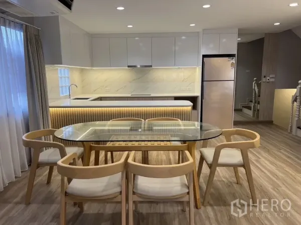 บ้าน ให้เช่าในBang Rak, Bangkok - โต๊ะอาหารกระจก 6 ที่นั่ง ข้างครัวโทนขาวลายหินอ่อนพร้อมไอส์แลนด์และตู้เย็นสแตนเลส