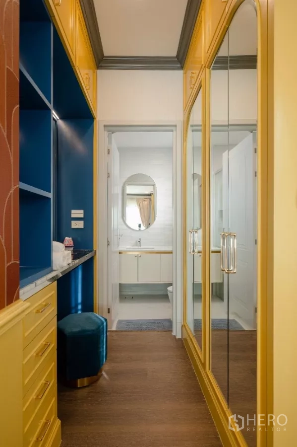 Detached House for rent or sale in Khlong Toei, Bangkok - Walk-in dressing area with mirrored yellow wardrobes and a blue vanity leading to an ensuite.