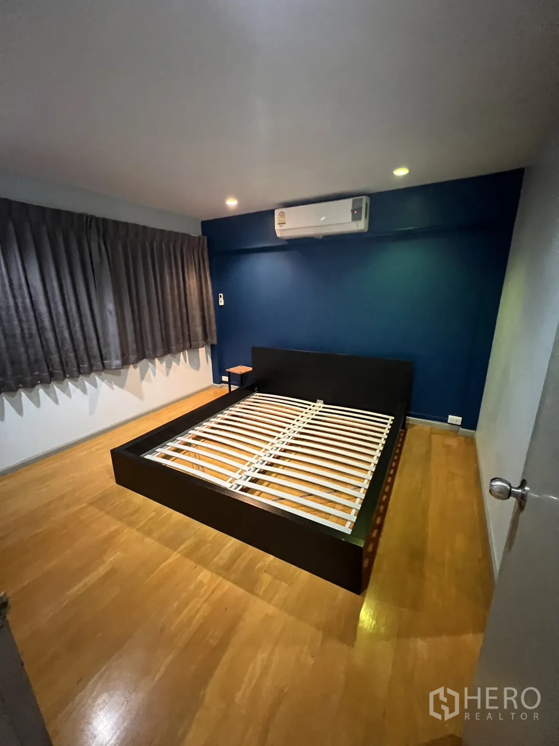 联排别墅 出租在Watthana, Bangkok - 卧室配平台床架、空调与木地板。