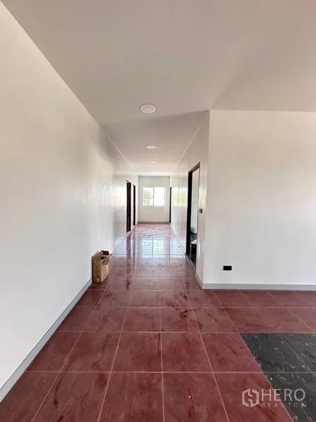 Warehouse for sale in Bang Phli, Samut Prakan - Upstairs corridor with red floor tiles leading to multiple rooms and bathrooms.