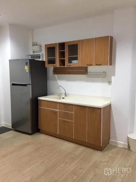 ทาวน์เฮาส์ ให้เช่าในLat Phrao, Bangkok - มุมครัวพร้อมตู้ล่าง-ตู้บน อ่างล้างจาน และตู้เย็นสแตนเลส พื้นลามิเนต