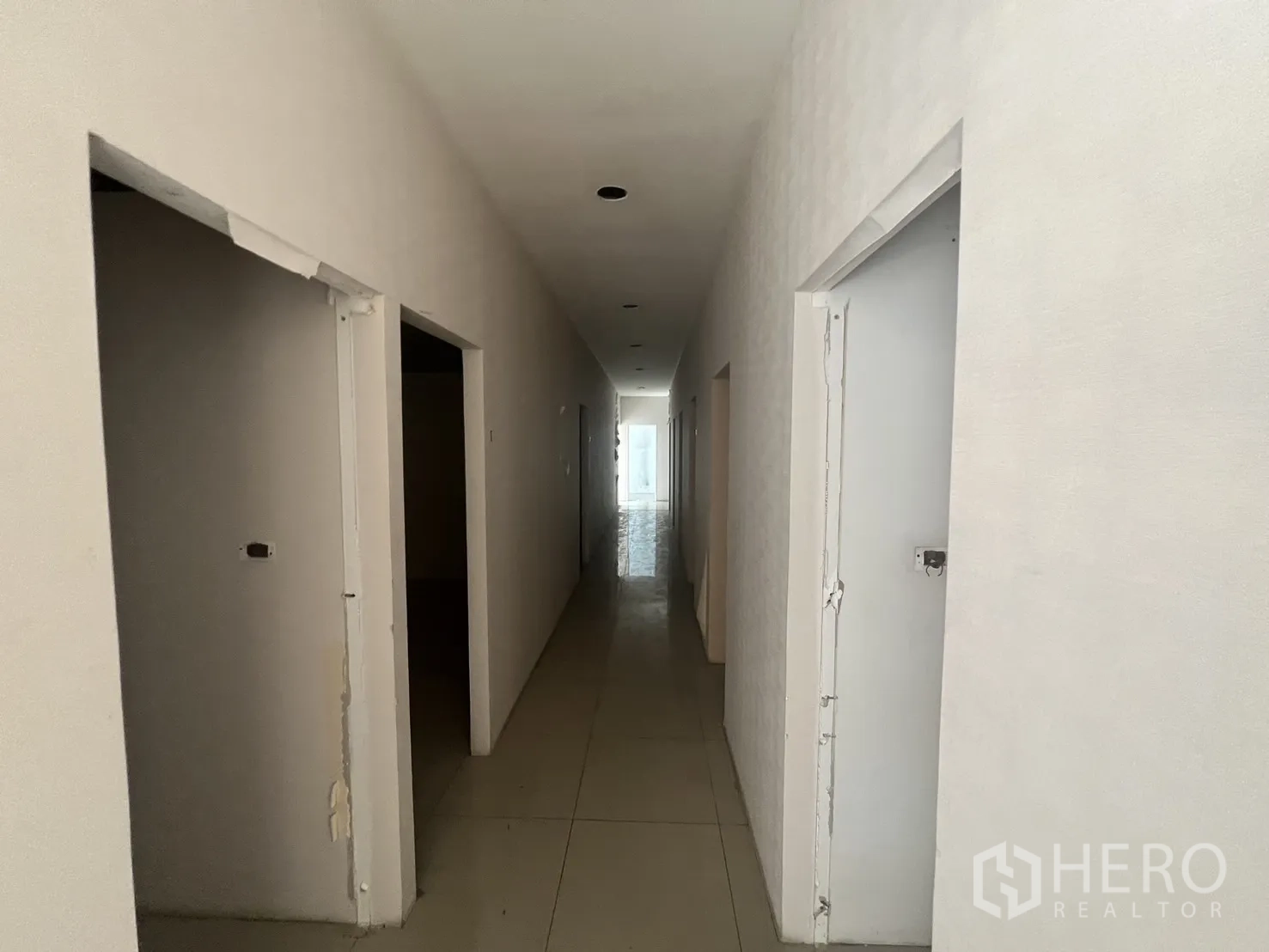 พื้นที่ขายปลีก ให้เช่าในKhlong Toei, Bangkok - มุมมองตามแนวโถง เห็นวงกบประตูที่ยังไม่เสร็จและไฟฝังฝ้า