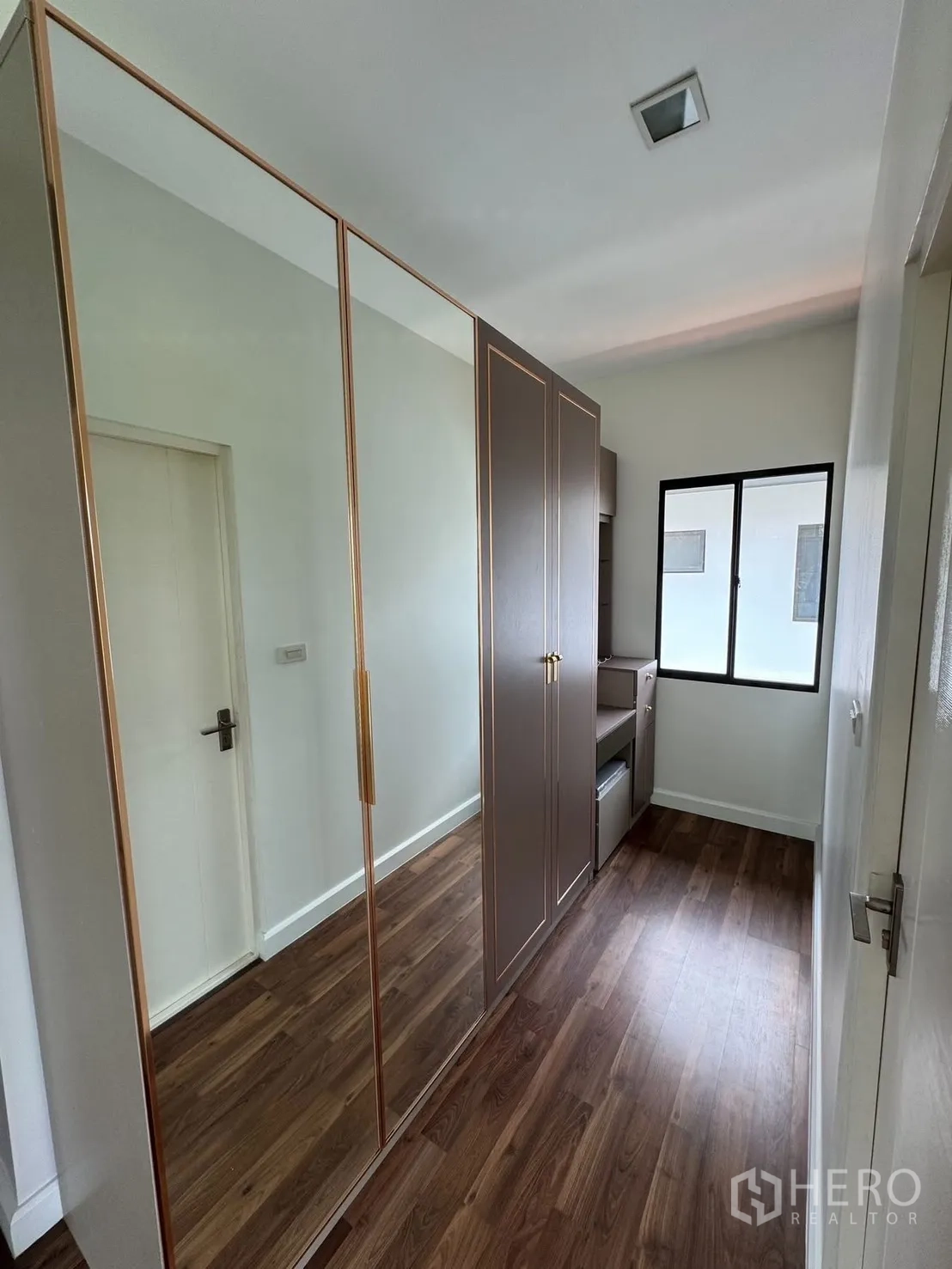 Detached House for rent in Prawet, Bangkok - Compact dressing area with mirrored wardrobe and wood floors.